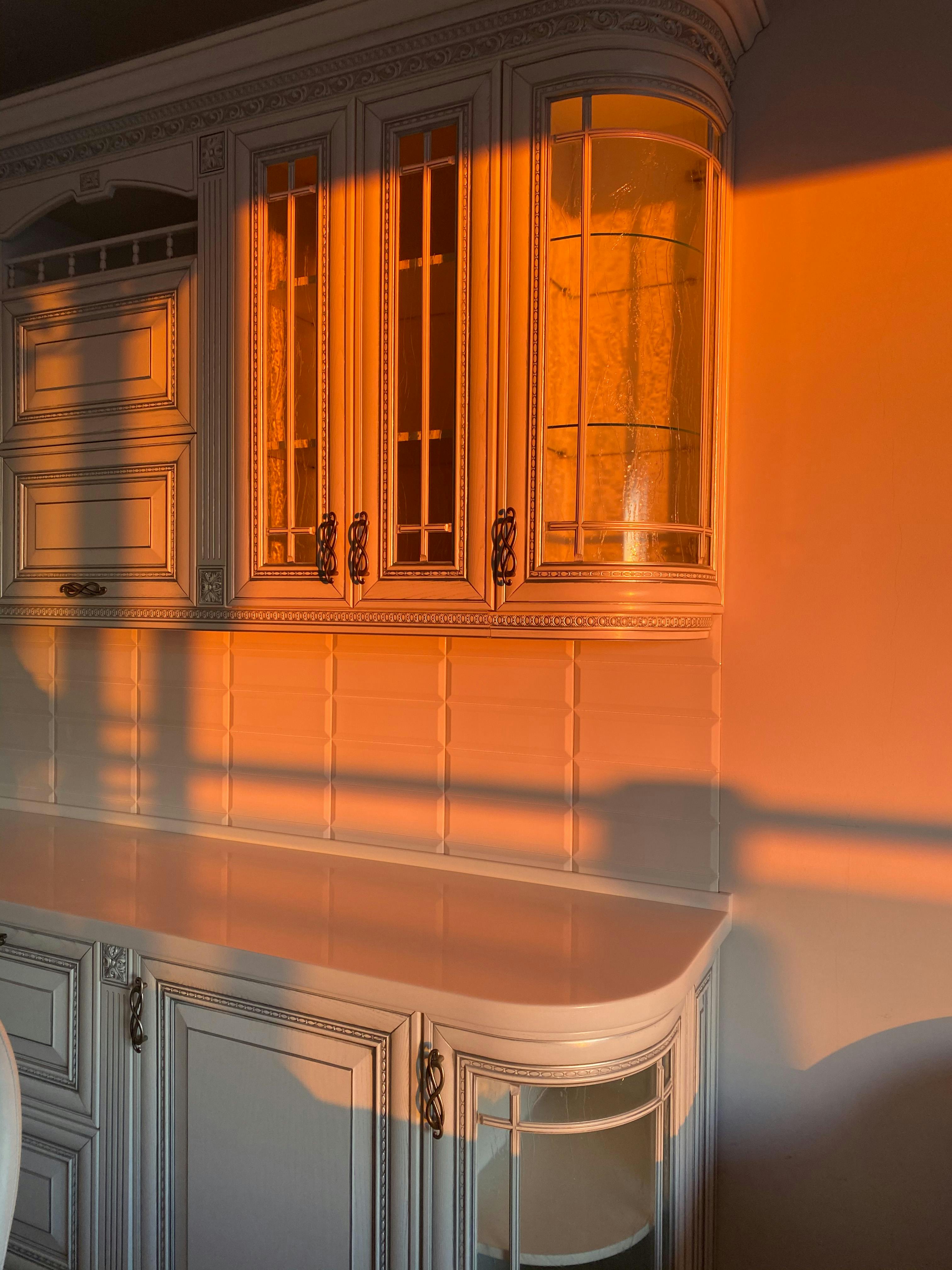 Elegant wooden cabinet illuminated by warm sunrise lighting, creating serene home atmosphere.