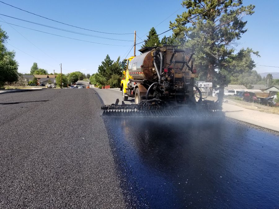 Paving equipment resurfacing a retail parking area