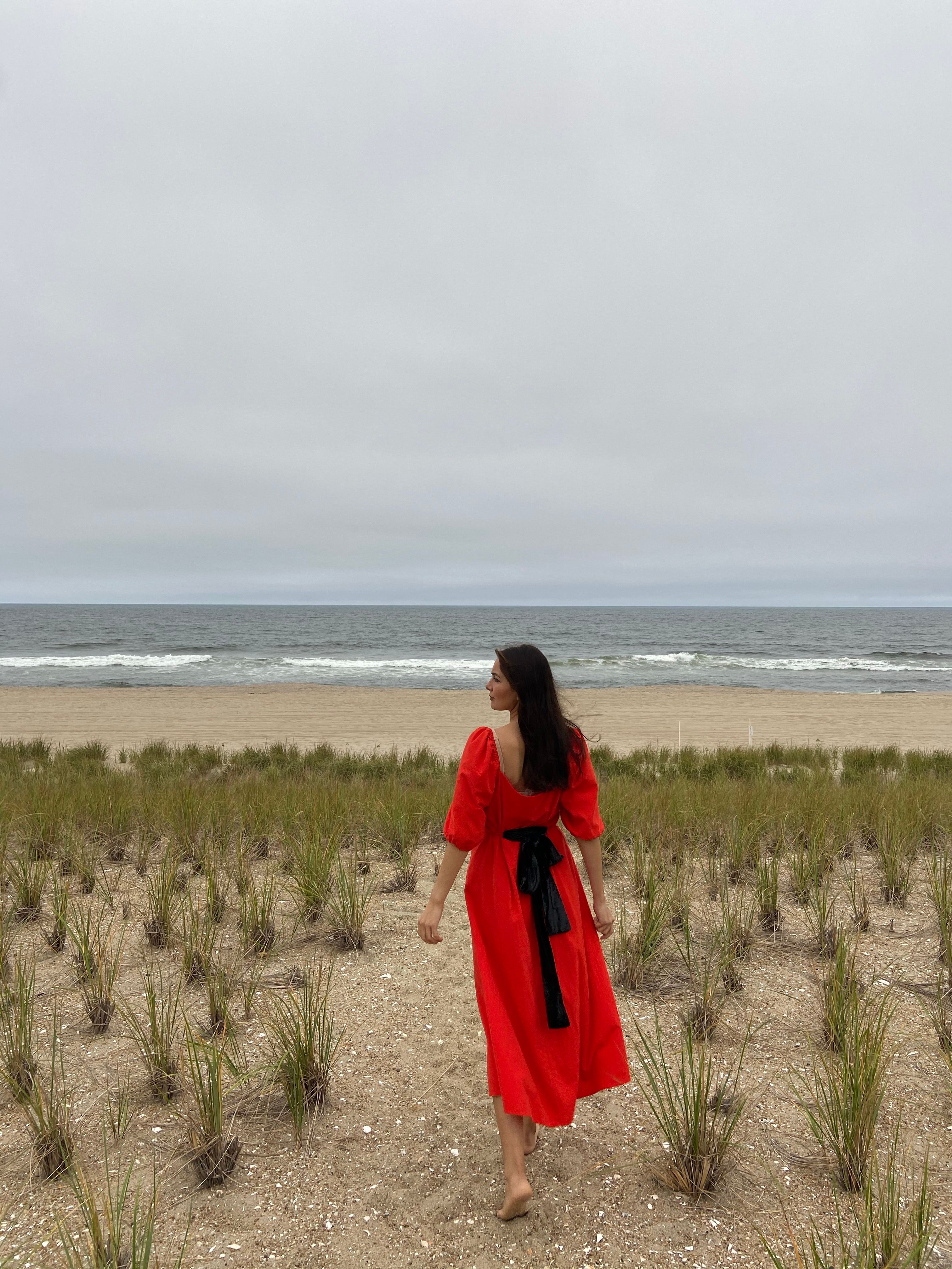 Woman in Red Dress Walking on Sand Near the Beach · Free Stock Photo