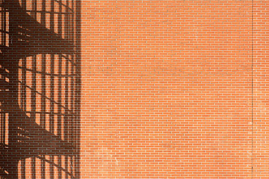 Photo of a brick wall with interesting shadow patterns from stairs.