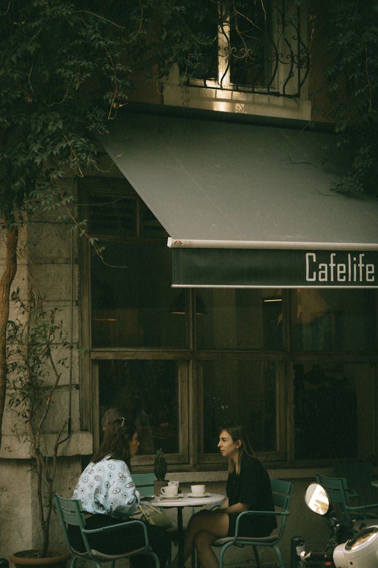 Women Sitting Outside The Cafe