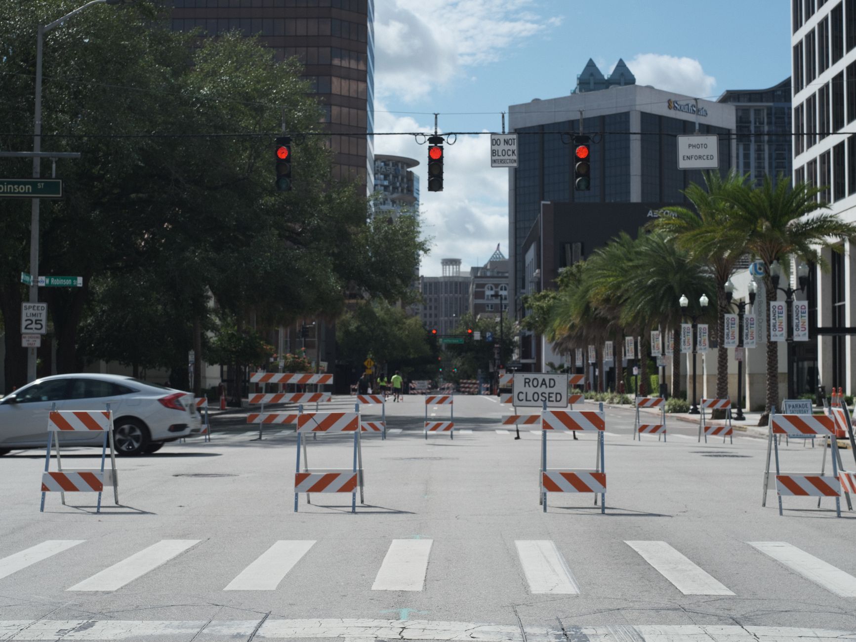 Photo by Raphael Loquellano A downtown city intersection with road closures, traffic lights, and tall buildings.