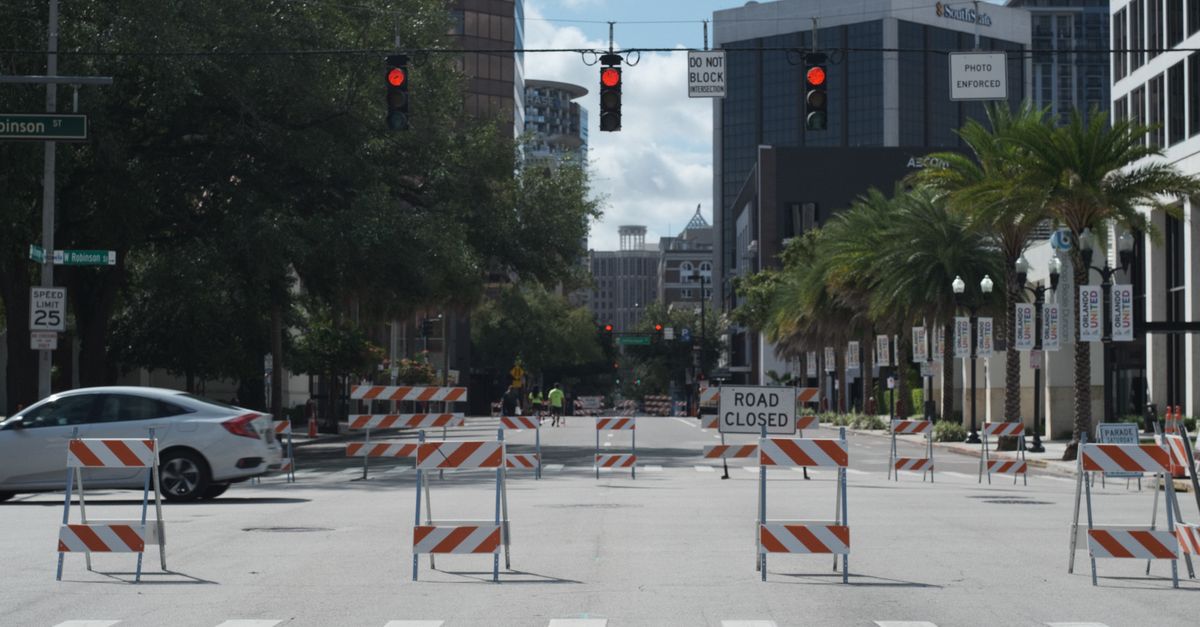 Photo by Raphael Loquellano A downtown city intersection with road closures, traffic lights, and tall buildings.