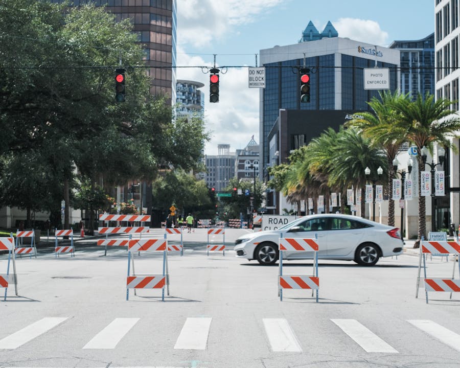 Free Downtown Orlando street view with traffic barriers and palm trees under a bright sky. Stock Photo