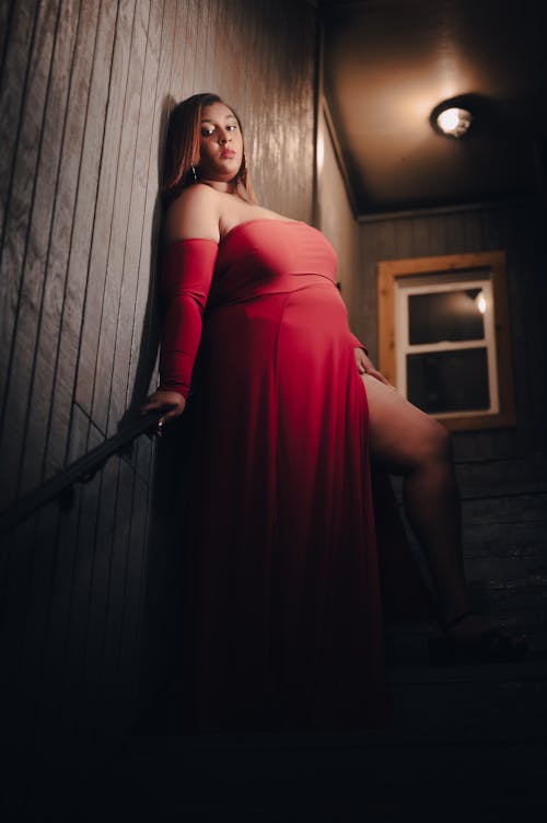Woman in Red Dress Standing on Stairs