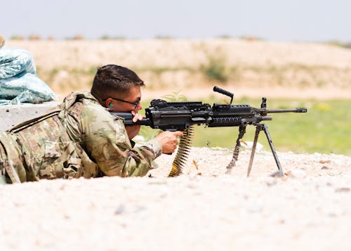 Soldier Lying on the Ground and Pointing a Rifle 