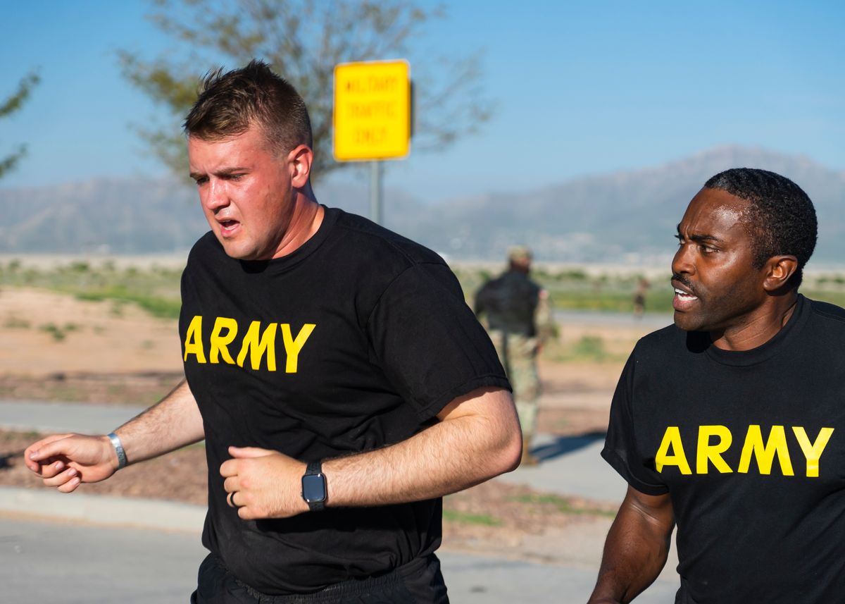 Two service members jogging outdoors during physical training