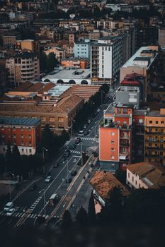 Drone view of a vibrant city showcasing streets, buildings, and architecture at dusk.