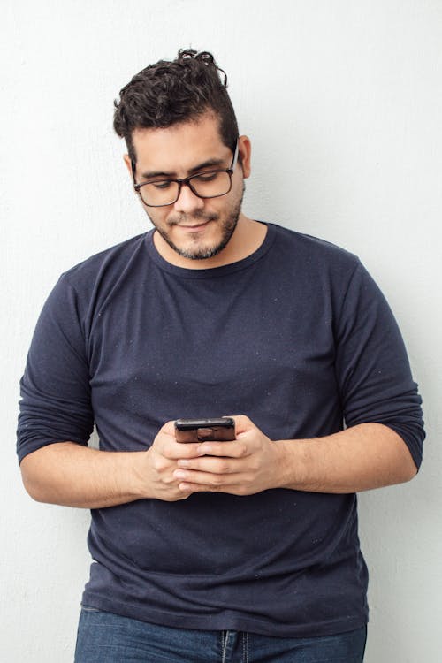 Man in Blue Crew Neck T-shirt Holding Black Smartphone