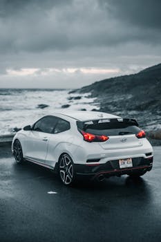 Capture of a white car parked by a stormy coast under a dramatic sky.
