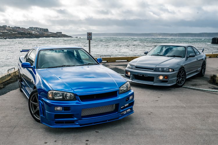 Two Cars Parked By A Sea