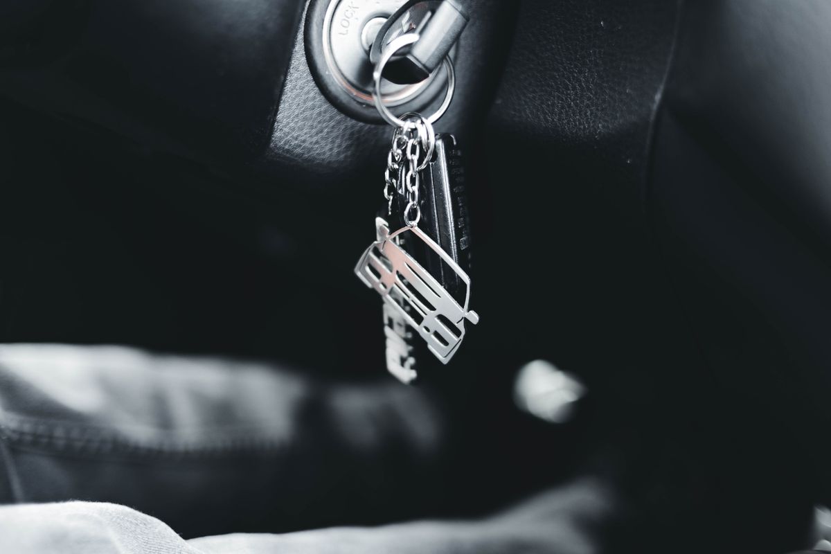 Close-up of car keys with a key ring on a wooden surface