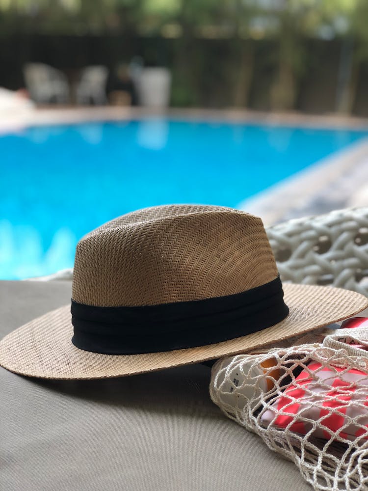 Beige And Black Hat Near Swimming Pool