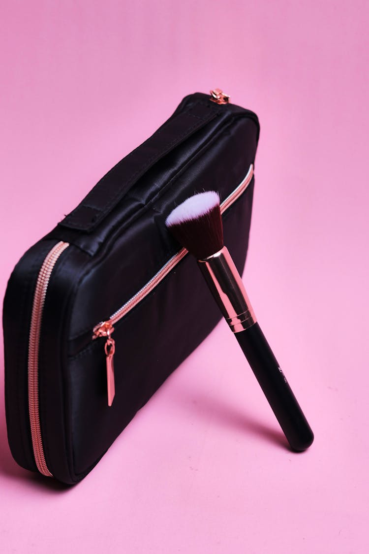 Makeup Brush And Cosmetic Bag On Pink Background