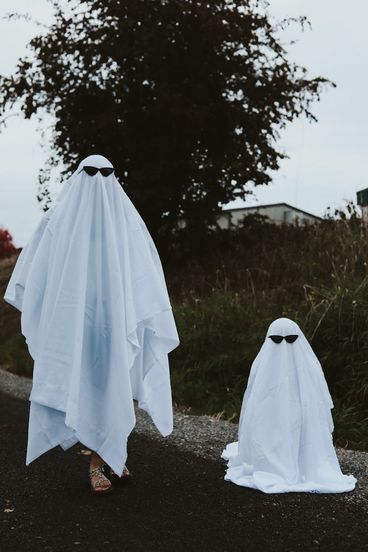 People Covered With White Blankets While Wearing Black Sunglasses 