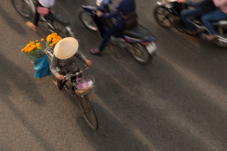 Top View Of People Riding Bicycles Through The Street In Asia 