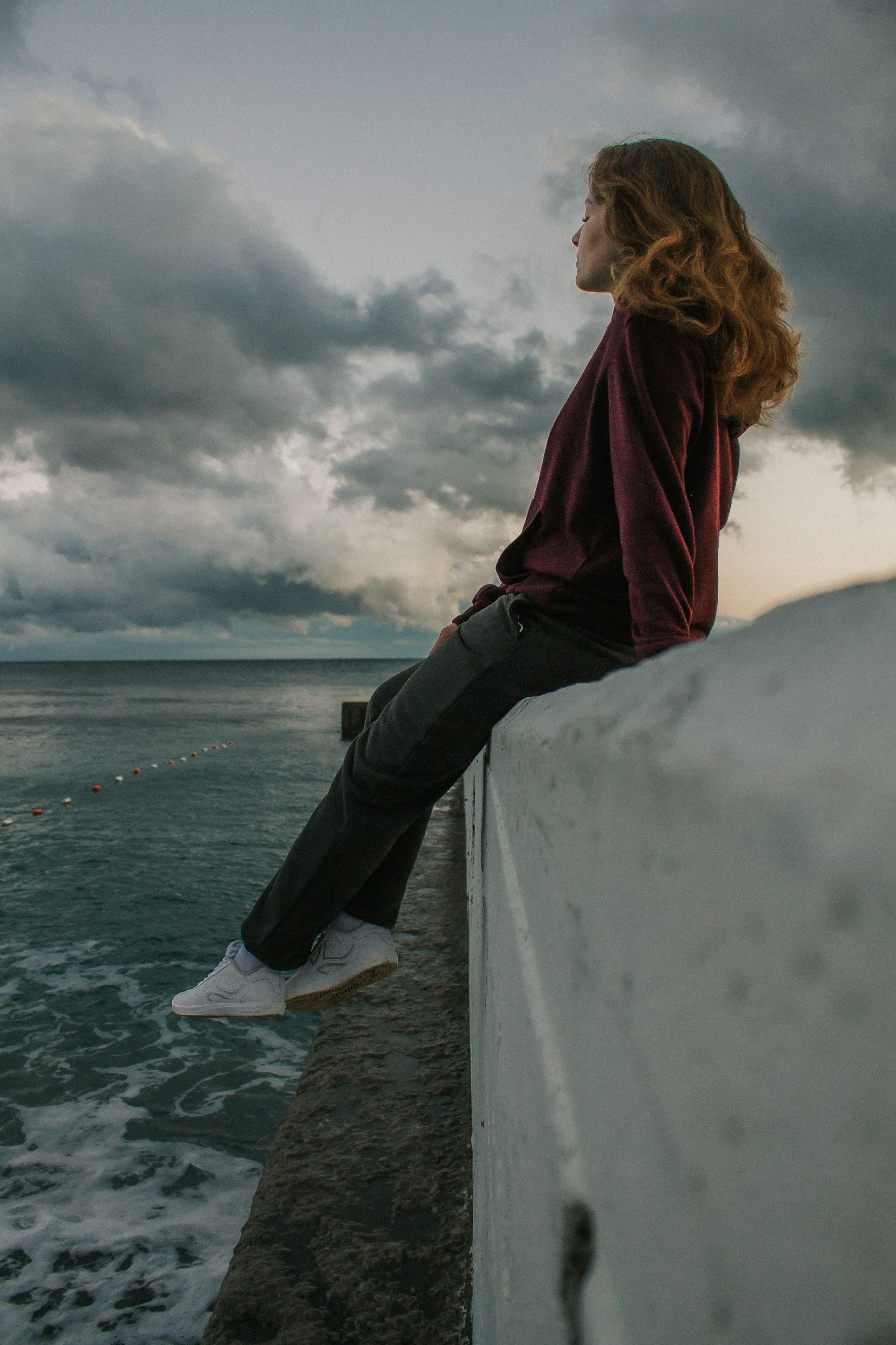 A Woman Sitting on the Sea Wall · Free Stock Photo