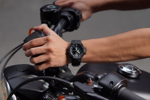 Free Close-up view of a person holding motorcycle handlebars, highlighting an analog watch. Stock Photo