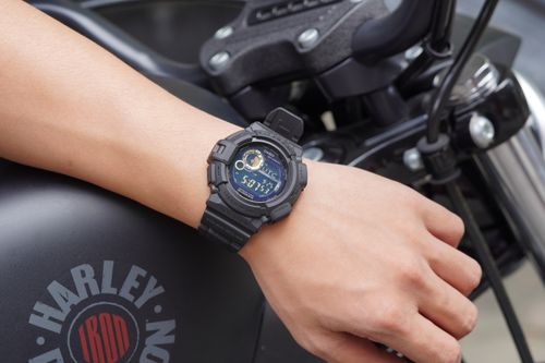 Free Closeup of a digital watch on a man's wrist, showcasing time on a parked motorcycle. Stock Photo
