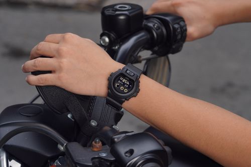 Free Detailed photo of a digital watch on motorcycle handlebars, highlighting time and biking theme. Stock Photo