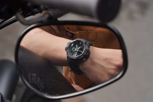 Free Close-up view of an analog watch in a motorcycle side mirror, capturing time with style. Stock Photo