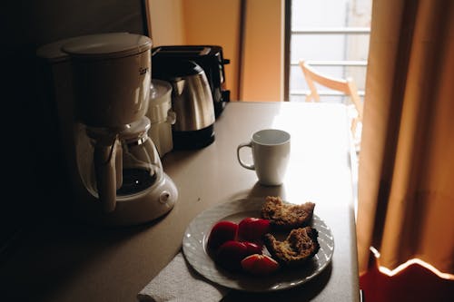 Taza De Cerámica Blanca Al Lado De Un Plato De Cerámica En La Mesa