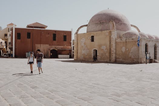 游客漫步在希腊克里特岛哈尼亚的历史建筑群附近，感受旅游与文化的魅力
