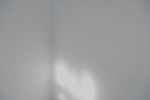 Abstract minimalist white wall with soft lighting, ideal for backgrounds.