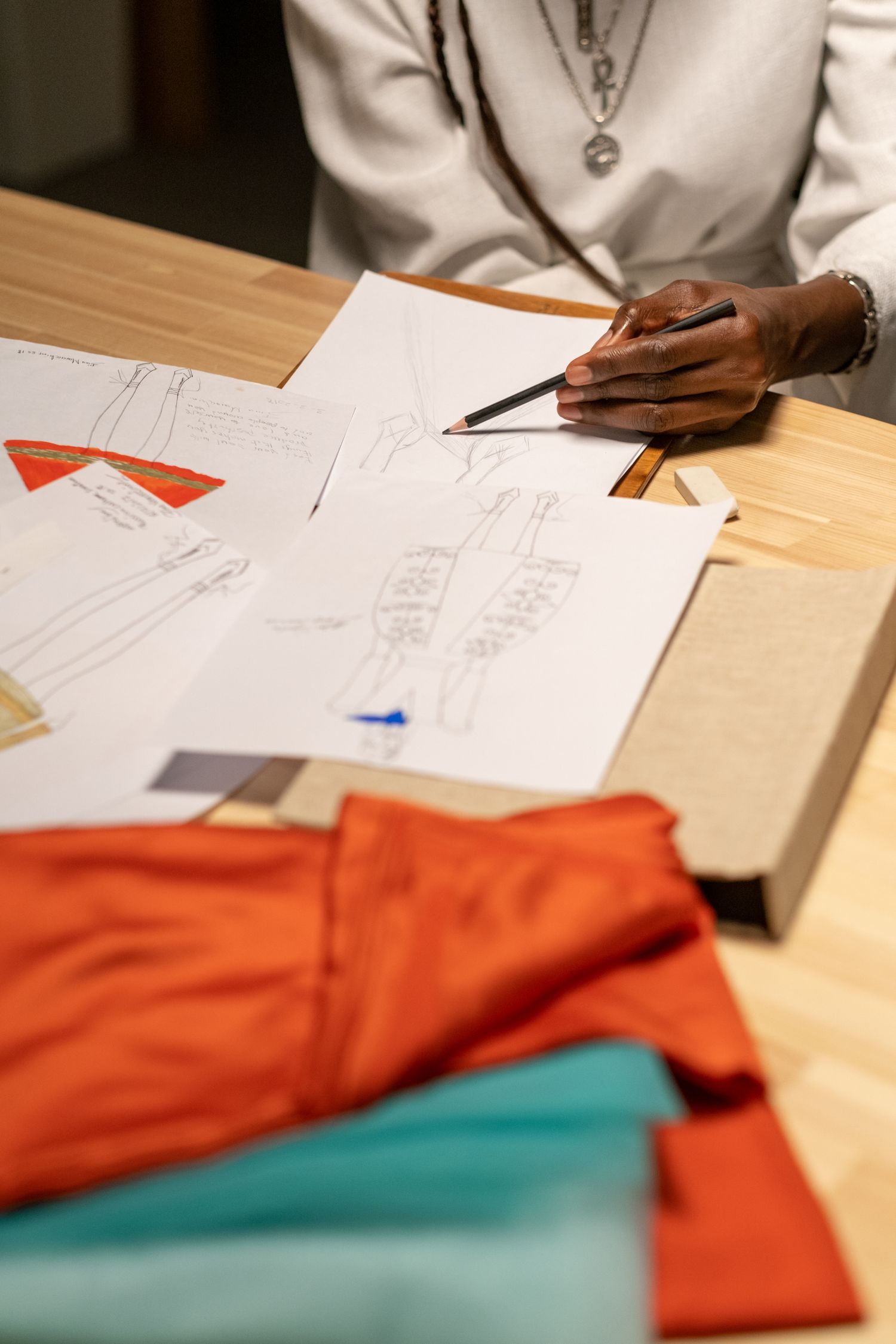 Designer developing fashion sketches with fabric samples