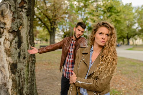 Frau Und Mann Tragen Braune Jacken, Die Nahe Baum Stehen