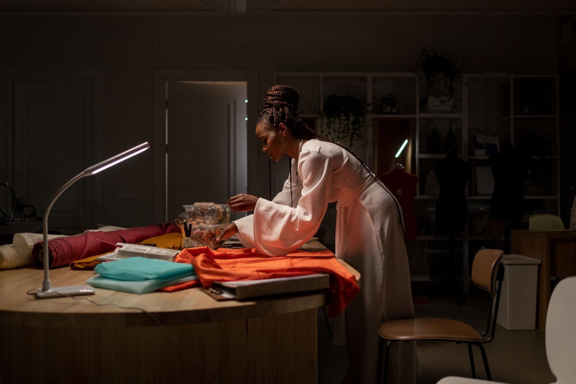 A minimalist luxury atelier featuring a fusion of traditional craft tools and advanced holographic digital interfaces.
