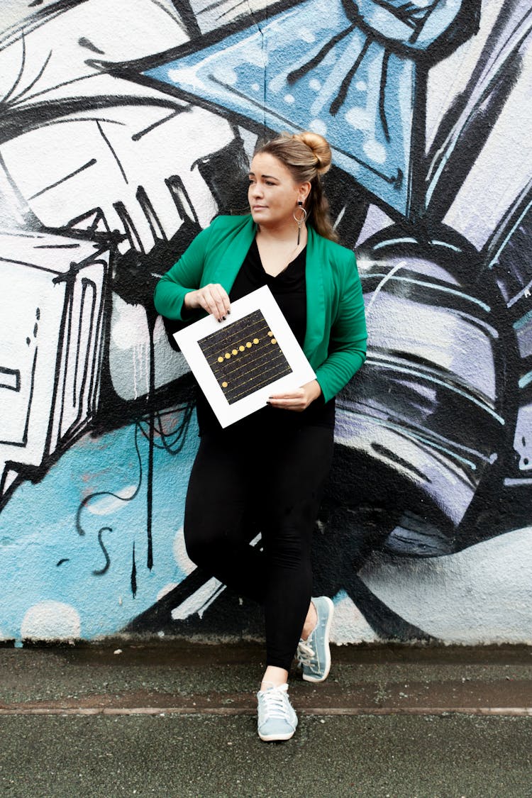 A Woman In Green Blazer Holding A Poster