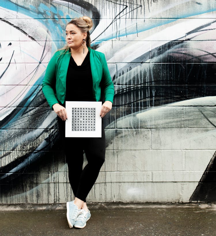 A Woman In Green Blazer Holding A Poster
