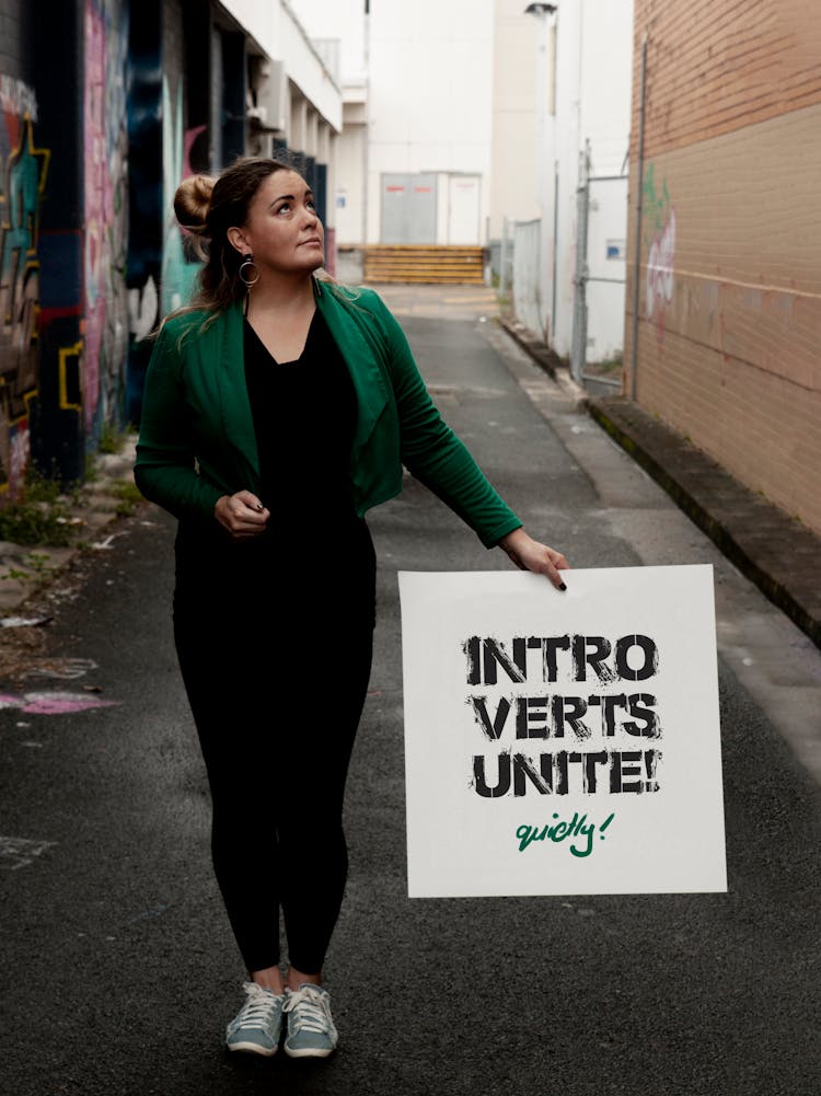 A Woman In Green Blazer Holding A Poster