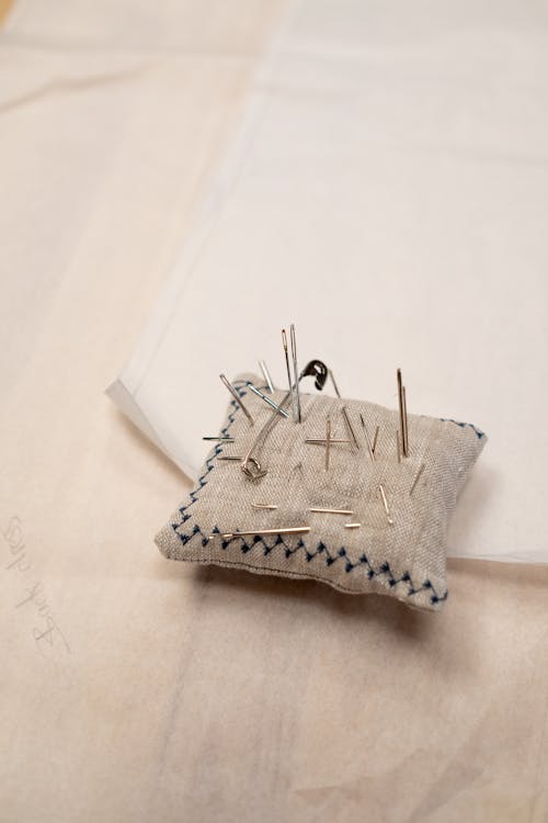 A close up on Pillow with Needles and Pin in It 