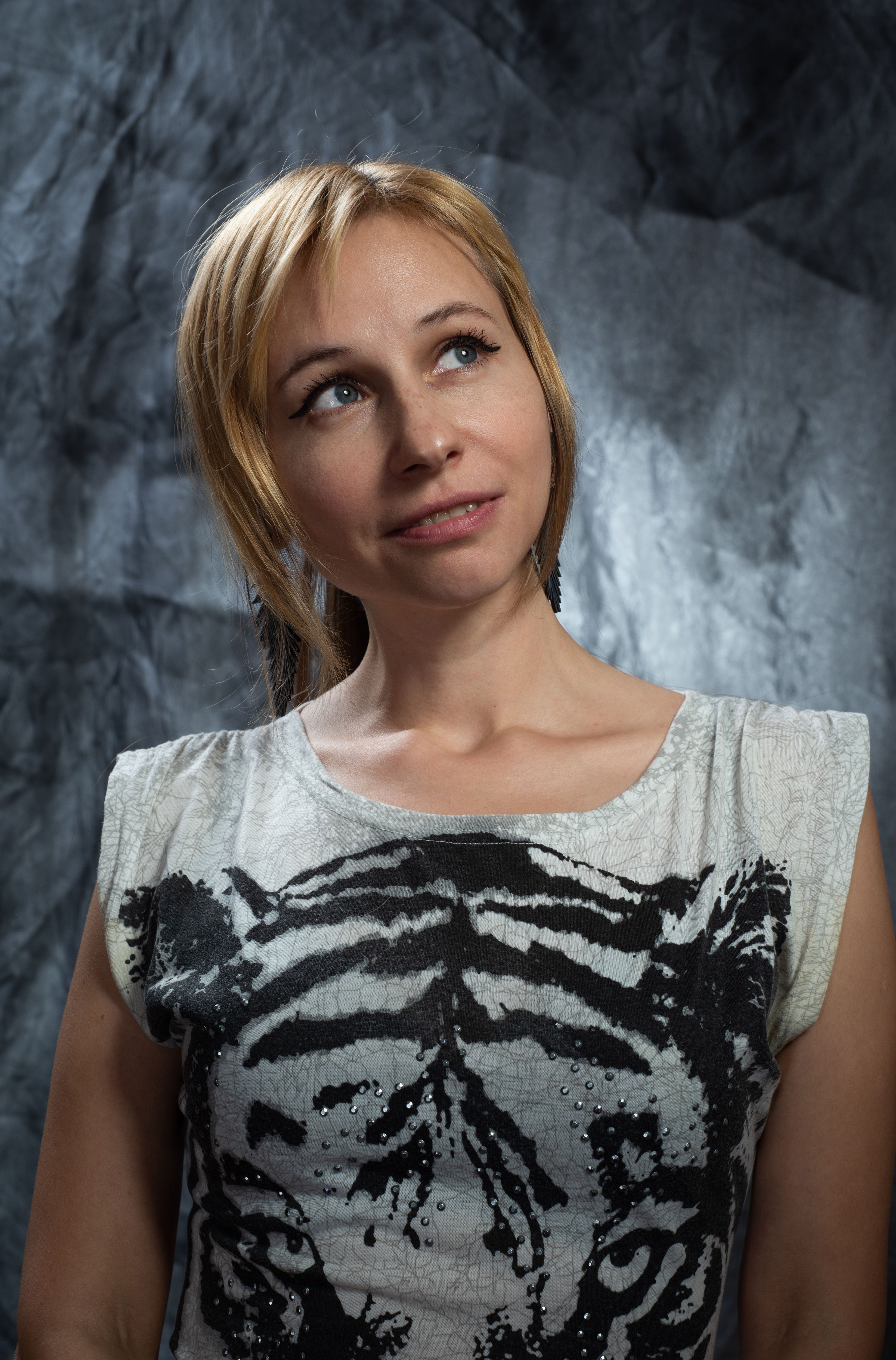 A contemplative woman in a tiger print top, photographed in a studio with a textured backdrop.