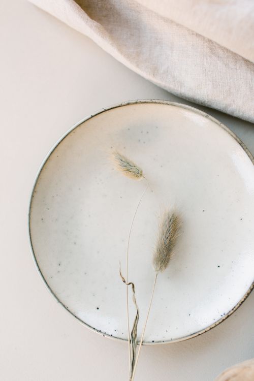 Free Elegant minimalist ceramic plate with dried grass on a soft, neutral background, ideal for modern design themes. Stock Photo