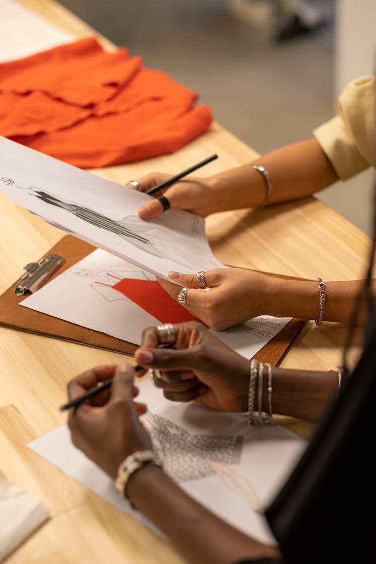 A Female Hands Holding Fashion Sketches