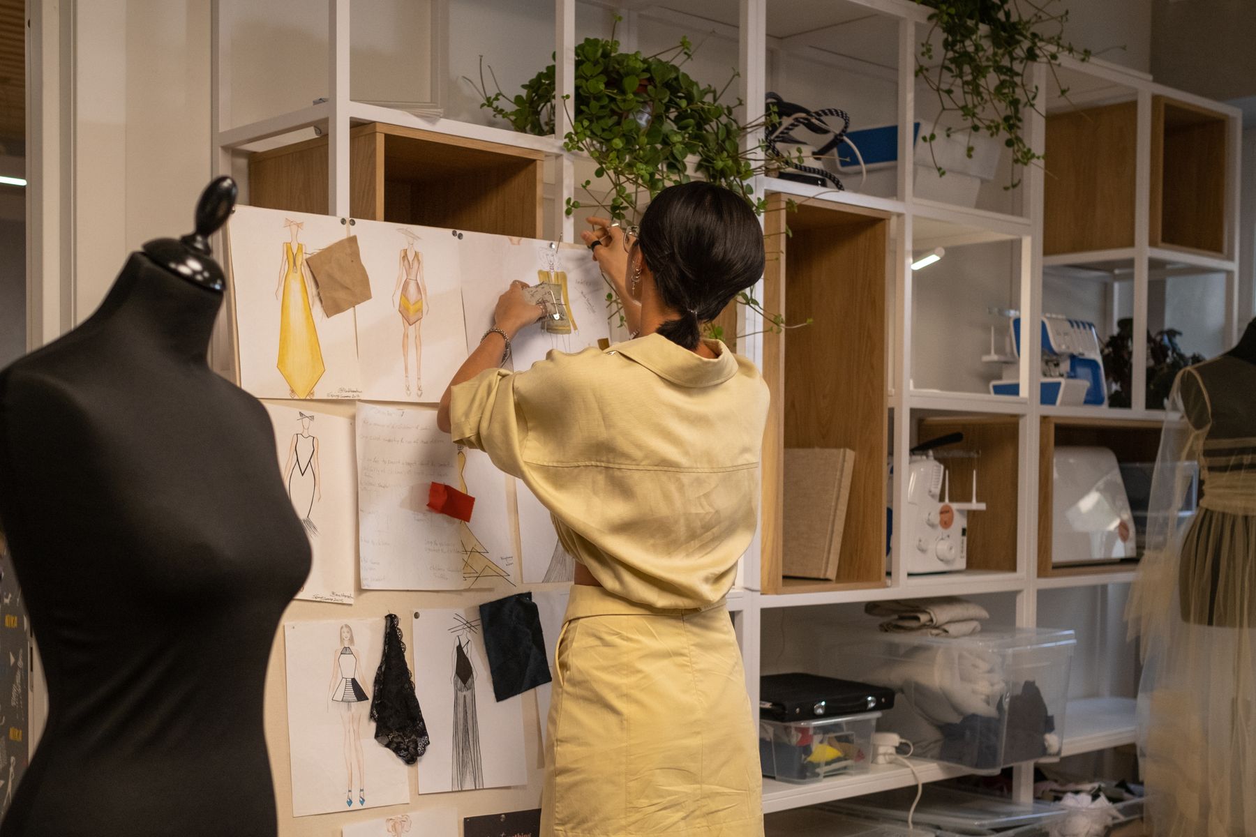 Fashion designer arranging sketches and fabric samples on a mood board
