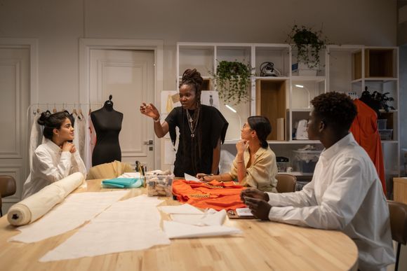 Design team working around a table in an atelier — photo by Ron Lach on Pexels