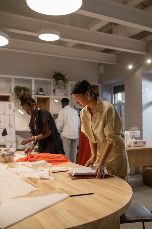 Free Fashion designers collaborating on new textile creations in a modern atelier. Stock Photo