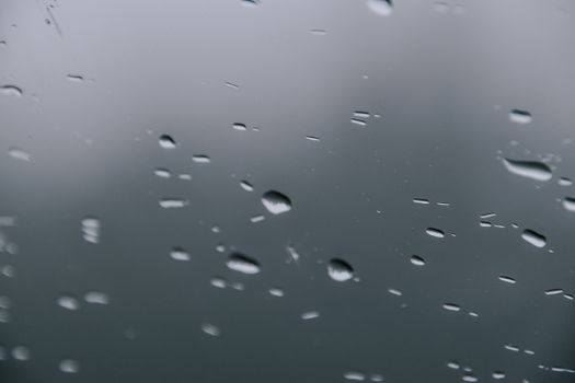 Captivating close-up view of water droplets on a glass pane, creating a serene and abstract visual effect.