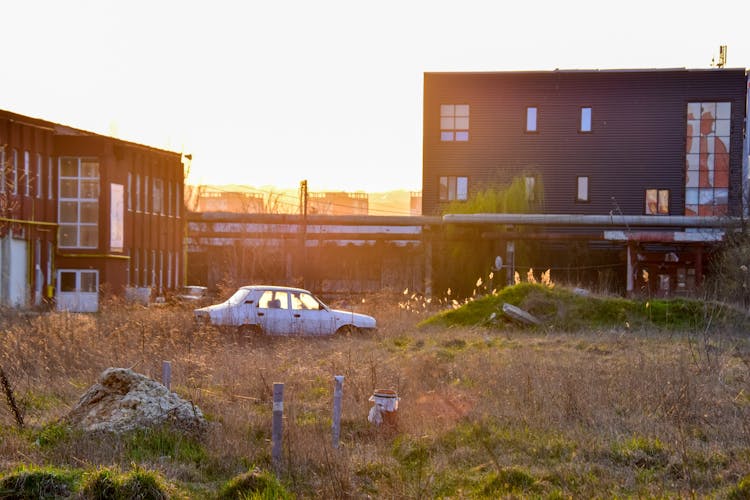 Abandoned Car In City Suburbs On Sunset