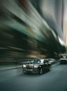 Black Rolls-Royce Racing Fast down Street of City