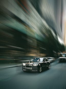 A luxury car speeds through a city street with dynamic motion blur emphasizing speed.