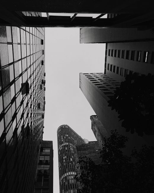 Low-angle black and white shot of skyscrapers forming a dramatic urban skyline.