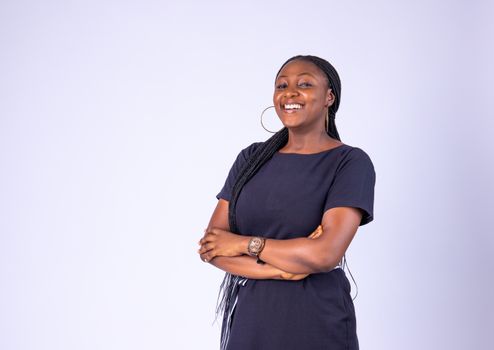 A joyful African woman poses confidently in a studio setting, exuding warmth and positivity.