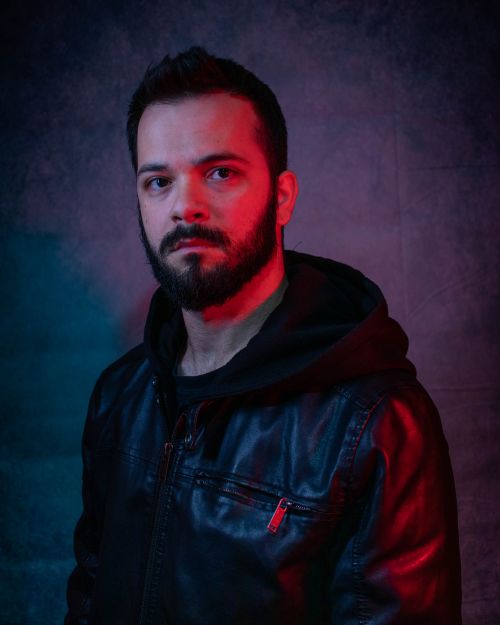 Free Portrait of a man in a black leather jacket with dramatic lighting in a studio setting. Stock Photo