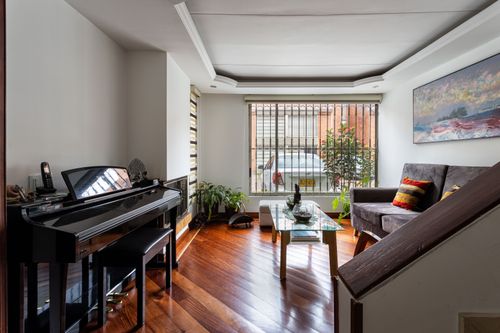 Free Bright living room featuring a grand piano, wooden floors, and stylish decor. Stock Photo