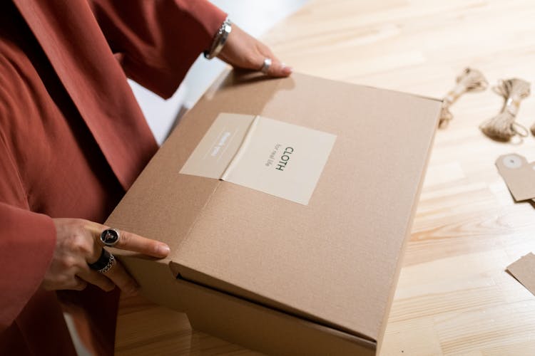 Person Holding A Brown Box